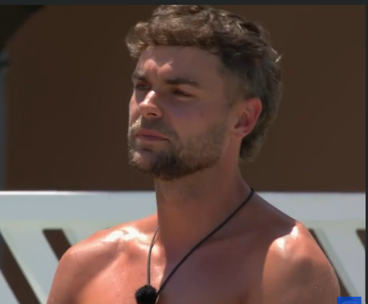 Screenshot of a man with short brown hair and a beard.