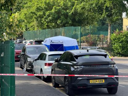 Crime scene with police tape and forensic tent.