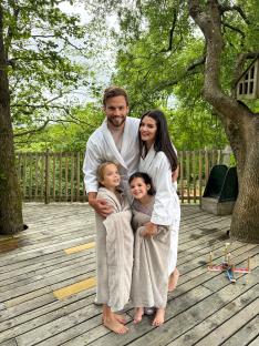 Emma with her two children and new partner James on a deck.