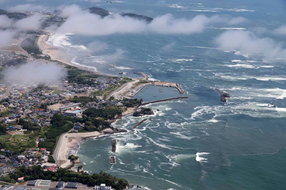 Aerial view of a Japanese coastline with a tsunami warning.