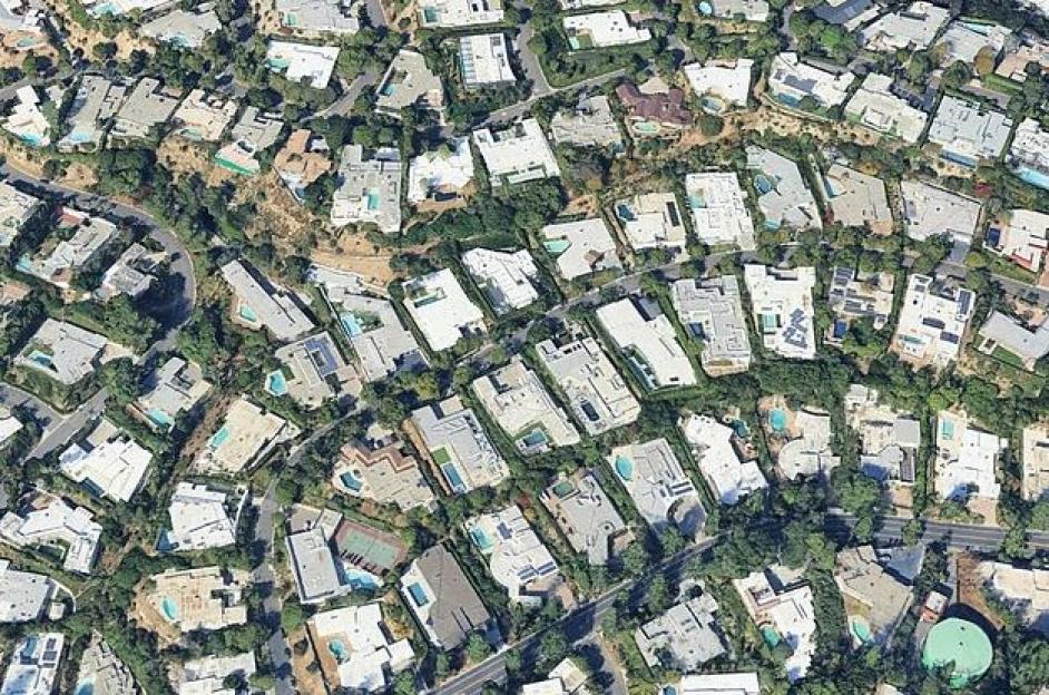 Aerial view of a neighborhood with many houses and swimming pools.