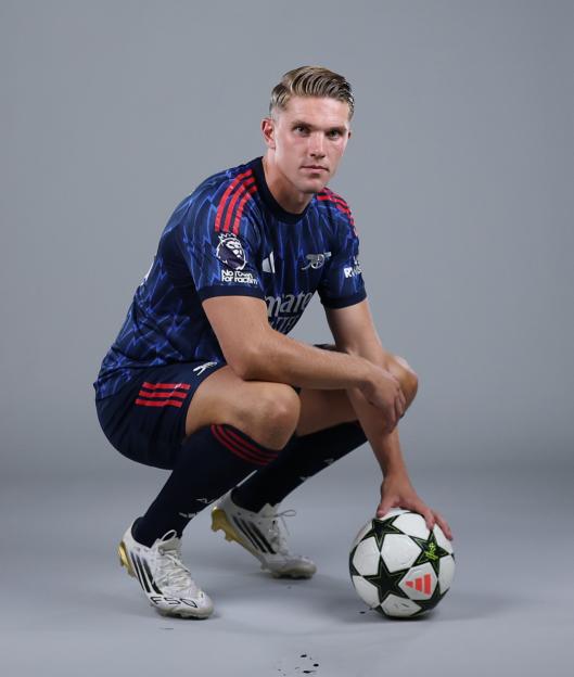 Viktor Gyokeres in Arsenal uniform, crouching with soccer ball.