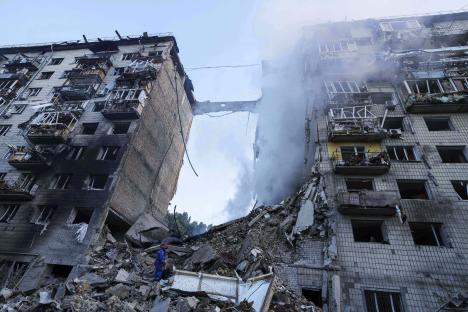 Rescue worker searching for survivors in rubble of bombed building.