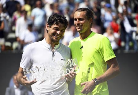 Taylor Fritz of the USA celebrates winning the Stuttgart Open with Alexander Zverev of Germany.