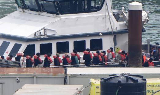 Migrants disembarking a Border Force vessel in Dover.