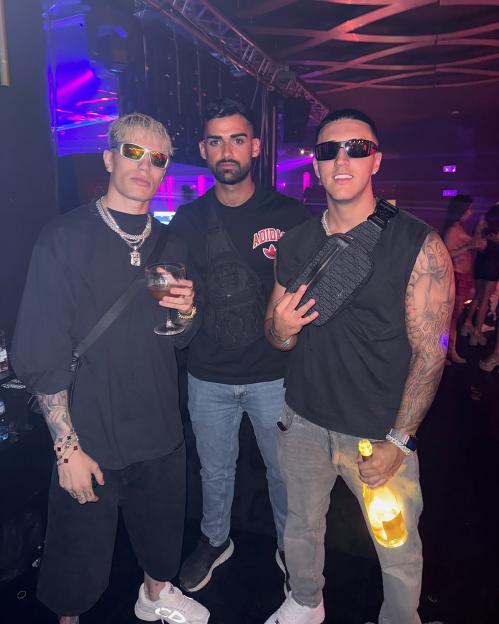 Three men posing together at a nightclub.