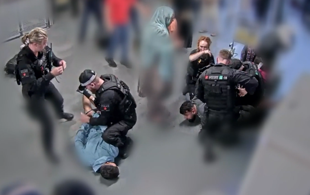 Police officers arresting a person at an airport.