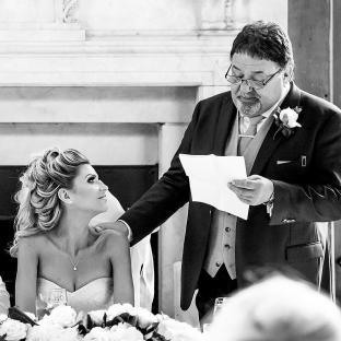 Black and white photo of a father giving a speech at his daughter's wedding.