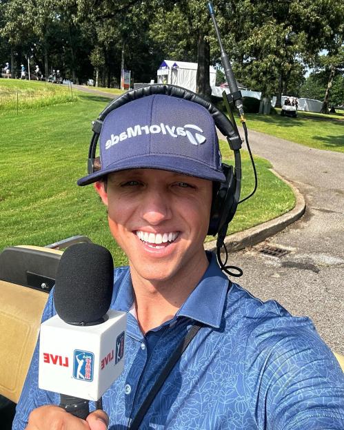Man holding microphone during live golf broadcast.