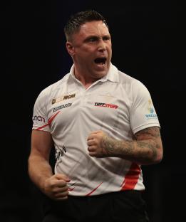 Gerwyn Price of Wales celebrates at a darts competition.