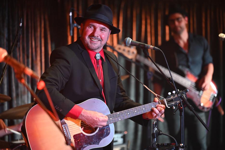 Alan Fletcher playing guitar on stage.