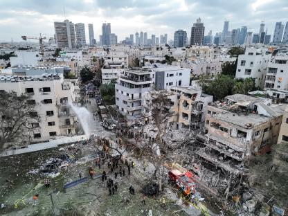Drone view of damaged residential buildings and emergency responders in Tel Aviv following a missile attack.