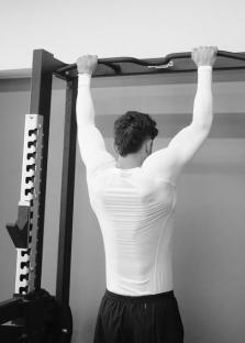 Man doing pull-ups in gym.