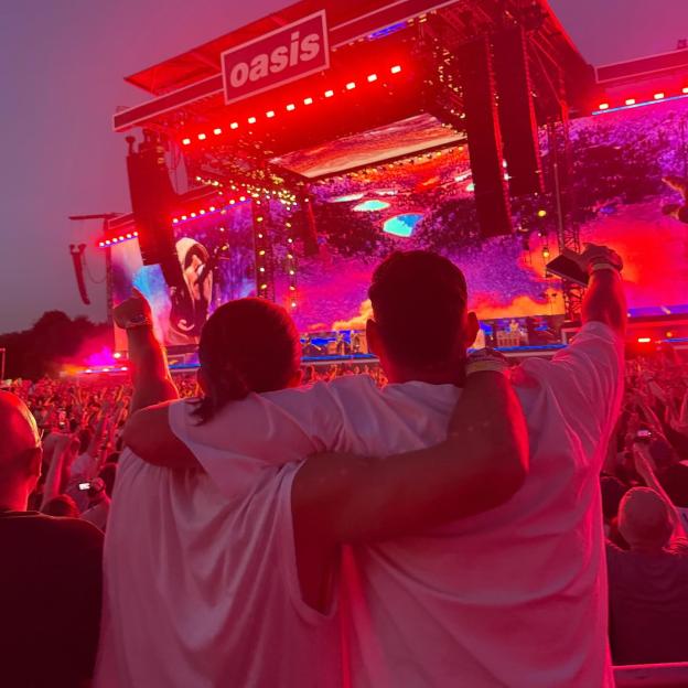 Couple embracing at an Oasis concert.