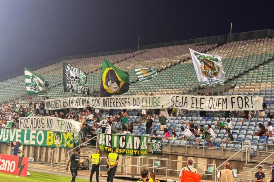 Sporting fans display banners at a stadium.