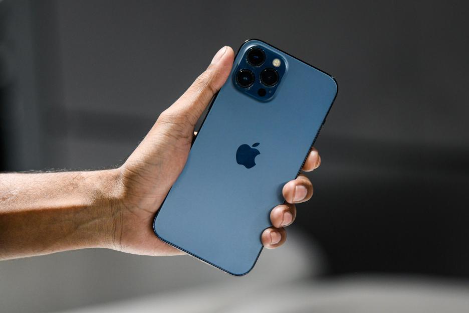 Photo illustration of a person holding an iPhone 13 Pro.