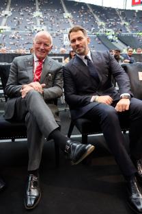 Eddie Hearn and his father Barry Hearn seated at a boxing match.