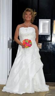 Woman in a white wedding dress holding a bouquet.