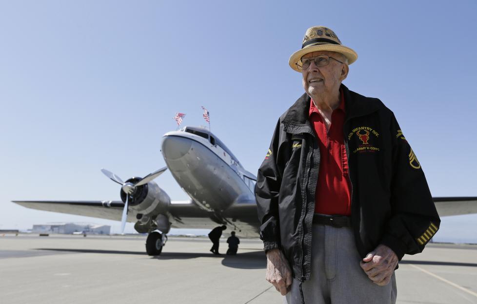 A D-Day veteran and a pilot holding hands.