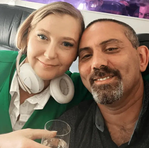 Couple celebrating with champagne on an airplane.