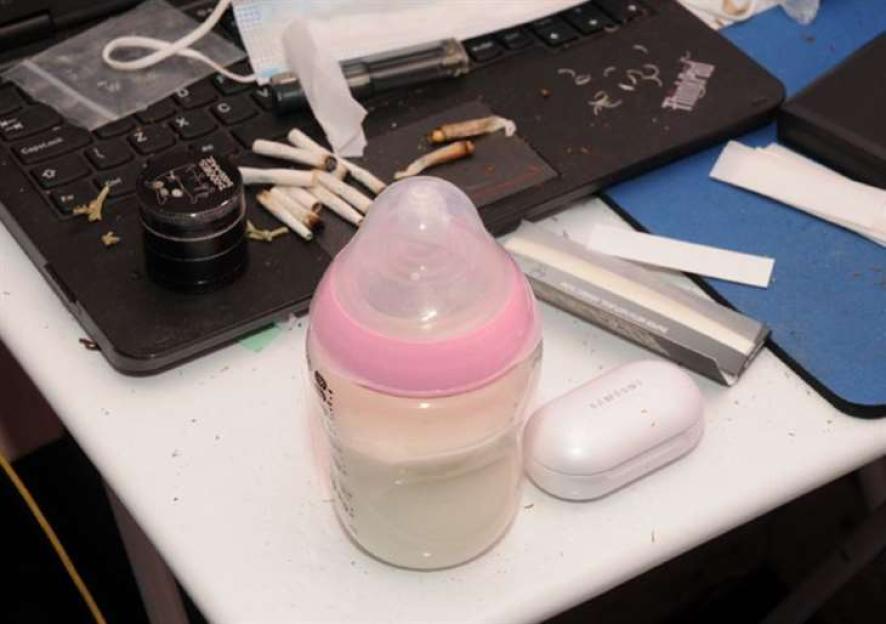 Baby bottle next to cannabis and drug paraphernalia.