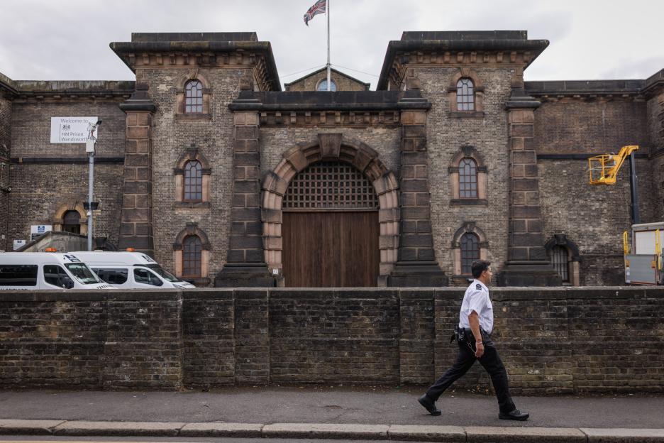 LONDON, ENGLAND - JULY 12: A prison guard walks past HMP Wandsworth prison on July 12, 2024 in London, England. The country's new justice secretary, Shabana Mahmood, announced today that the government will release thousands of prisoners early to alleviate overcrowding. Under the new policy, prisoners on