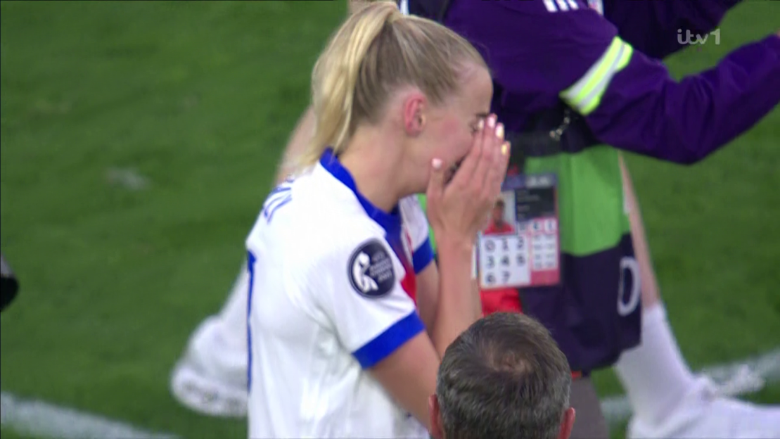 Upset female soccer player crying on the field.