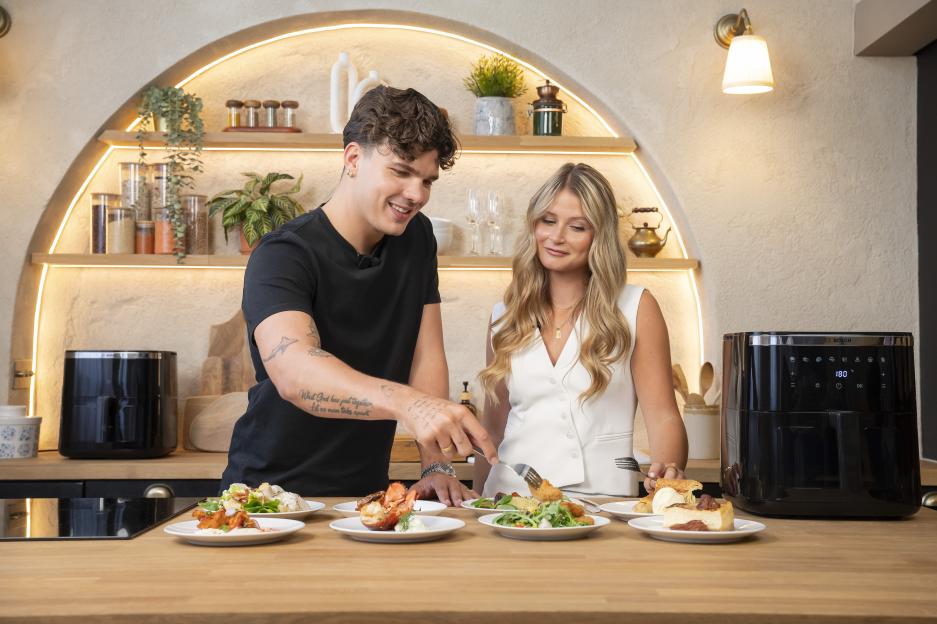 Two people taste-testing food prepared in a Bosch air fryer.