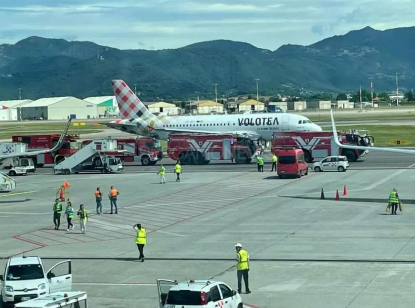 A Volotea airplane on a tarmac surrounded by emergency vehicles.