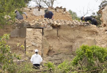 Police searching a dilapidated building during a search for evidence.