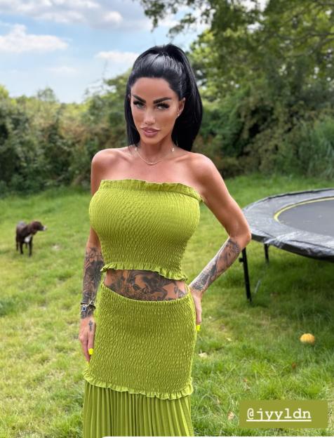 Woman in olive green two-piece outfit in a garden.