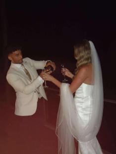 A bride and groom toasting with champagne at night.