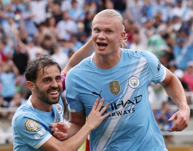 Erling Haaland and Bernardo Silva of Manchester City celebrating a goal.