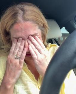 A woman crying in her car.