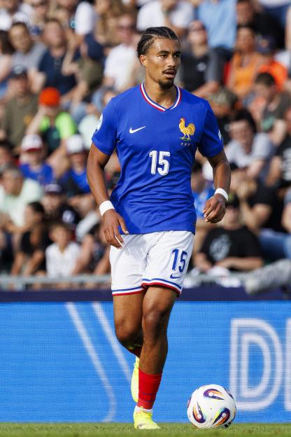 Nathan Zeze of France runs with the ball during a soccer match.