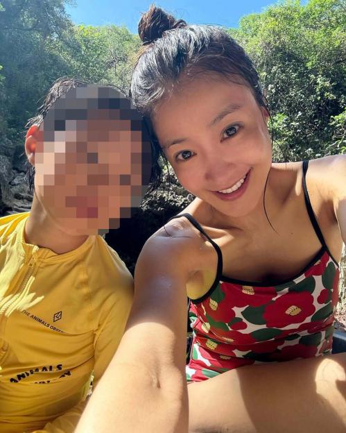 Woman and child in swimwear outdoors.