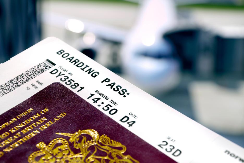 FX8J4R British Passport and boarding pass at the airport (Prague) Plane loading behind