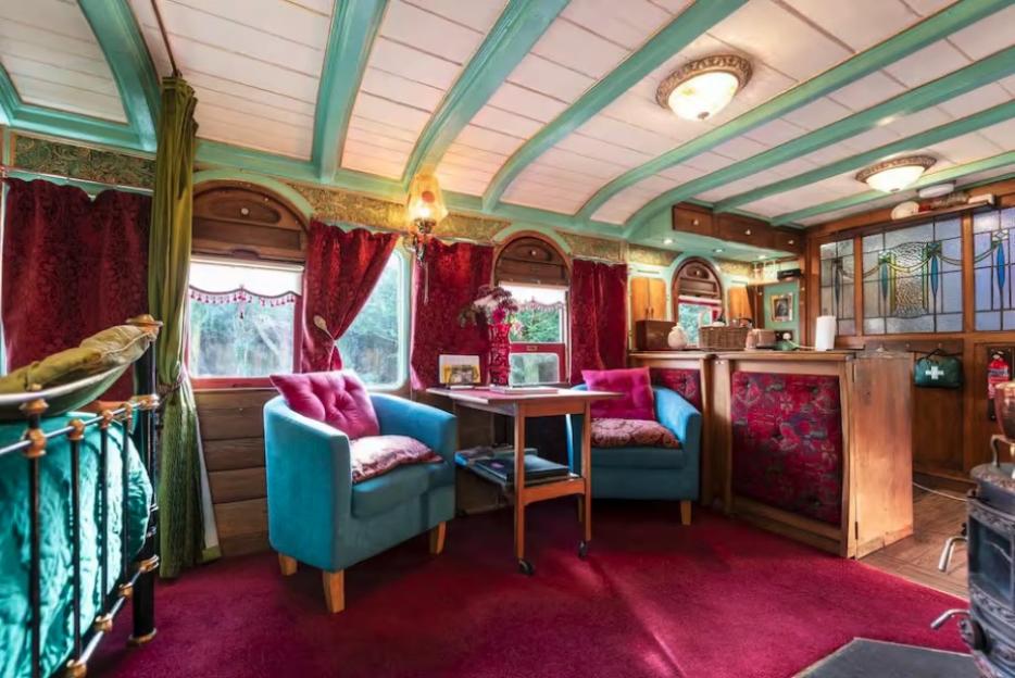 Interior of a restored 1895 GWR railway carriage, showing seating area and bed.