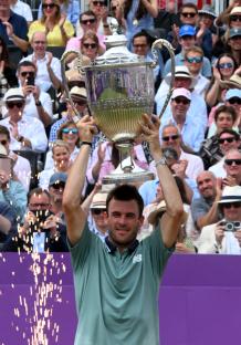 Tommy Paul holding a tennis trophy with his girlfriend.