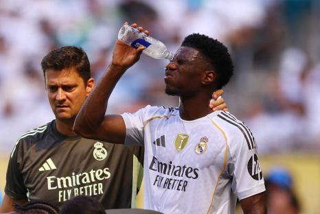 Aurelien Tchouameni of Real Madrid pours water on his face during a soccer game.
