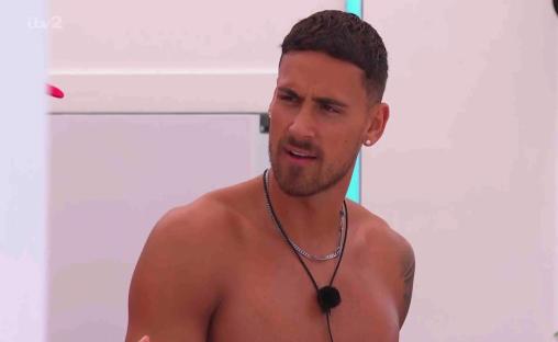 Shirtless man with short hair and necklaces looking to the side.