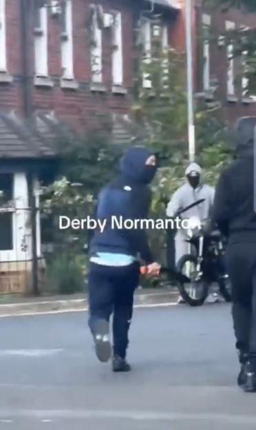 Person running on a street with others on motorcycles.