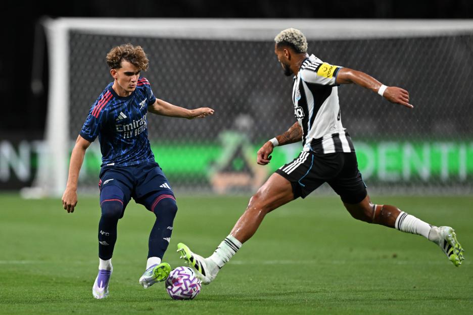 Arsenal's Max Dowman challenged by Newcastle's Joelinton during a soccer match.