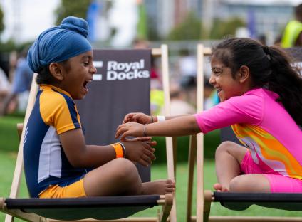 Two children laughing and playing together at Royal Docks lido.