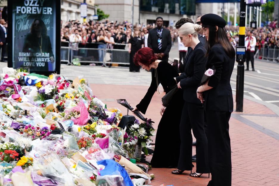 Sharon Osbourne and family members laying flowers at a memorial.
