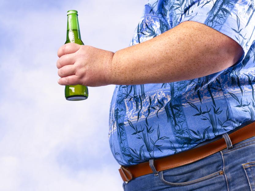 Overweight man holding a beer bottle.