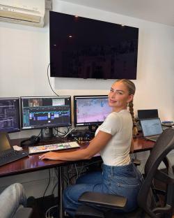 Woman sitting at a video editing workstation.