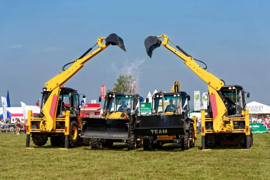 Two yellow excavators spraying water.