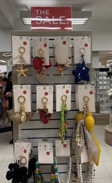 Various keychains and necklaces on display at a 50% off sale.