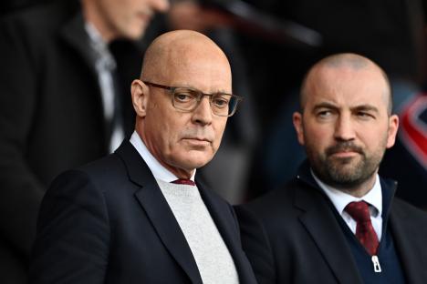 Sir Dave Brailsford and another man watching a sporting event.